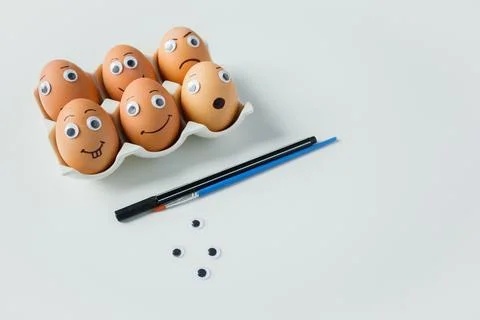 Creative Easter eggs decoration process: making eggs with funny emoji faces.. Stock Photos