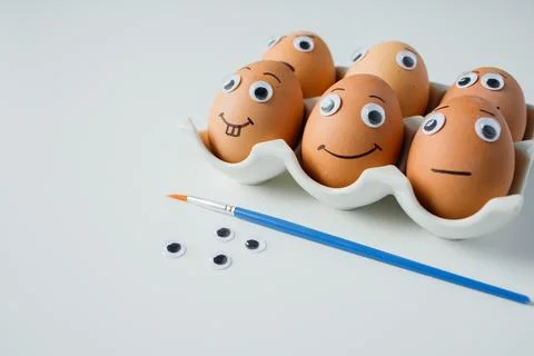 Creative Easter eggs decoration process: making eggs with funny emoji faces.. Stock Photos
