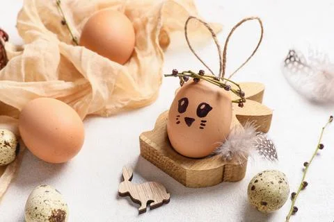 Creative Easter eggs with fabric, decorations and branches on white backgroun Stock Photos