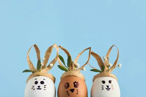 Creative Easter eggs with flowers on blue background, closeup Stock Photos