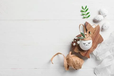Creative Easter eggs with rabbit and supplies on white wooden background Stock Photos