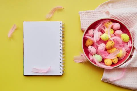 Creative Easter notepad mock up on yellow background. Decorated Easter: pink Stock Photos