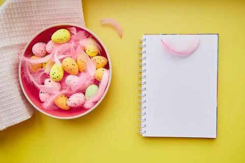 Creative Easter notepad mock up on yellow background. Decorated Easter: pink Stock Photos