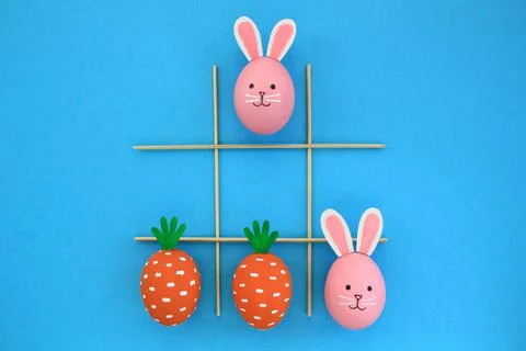 Creative easter theme eggs with carrot and bunnies on blue background Foto stock