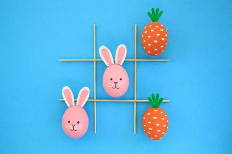 Creative easter theme eggs with carrot and bunnies on blue background Foto stock