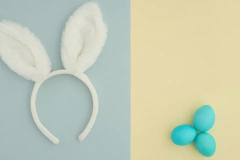 Creative Easter two-color background with rabbit ears and blue easter eggs. Copy Stock Photos