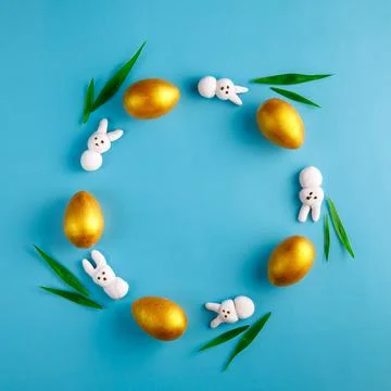 Creative Easter wreath made from golden wooden eggs, pink marshmallow bunny Stock Photos