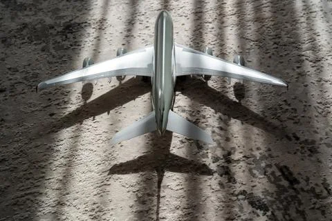 Creative effect with sun light beam, airplane aircraft toy on grey background Stock Photos
