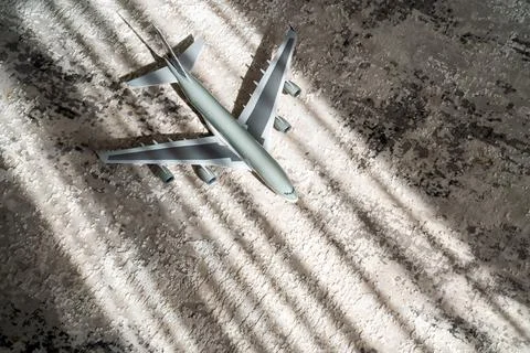 Creative effect with sun light beam, airplane aircraft toy on grey Fotos Stock