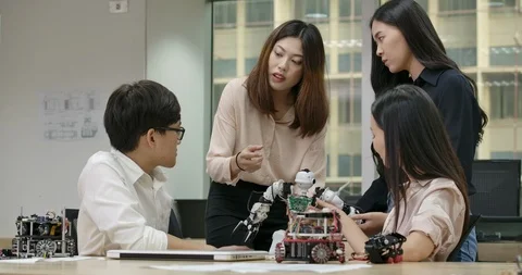 Creative engineers meeting, programming robotics at laptop in workshop Stock Footage 111839400