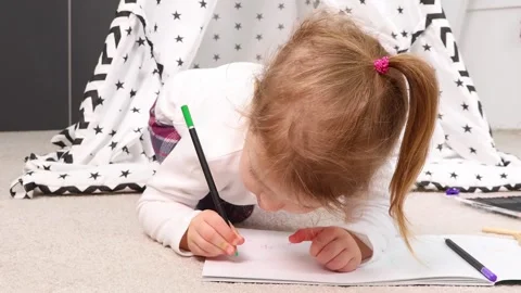 Creative exploration unfolds as child draws inside cozy tent space Stock-Footage 295355098