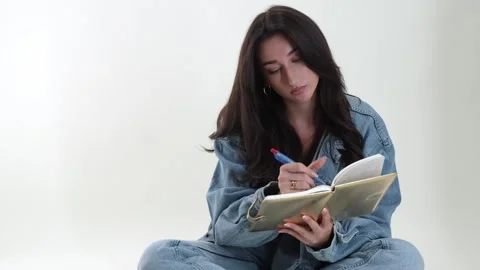 Creative expression and self-reflection, young woman writing in journal or Stock Footage 337005696