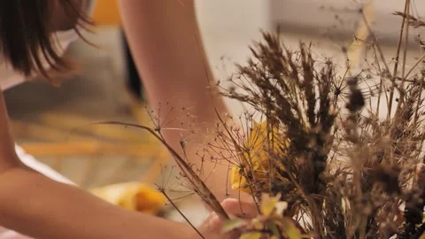 Creative Fall Crafting - Hands Decorating With Golden Leaves and Dried Plants 4K Video stock 303486414