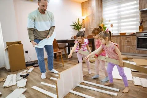 Creative family time while assembling furniture in a cozy home Stock Photos