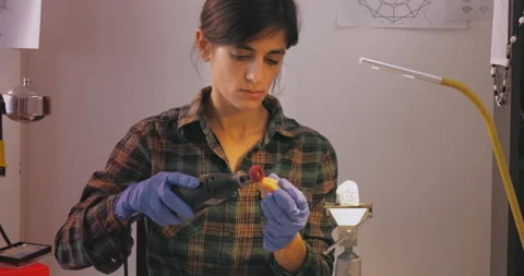 Creative female artist using different tools to shape the gemstone in workshop Stock Footage 143179387