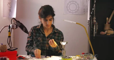 Creative female artist using different tools to shape the gemstone in workshop Stock Footage 143179459