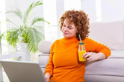 Creative female freelancer sitting front laptop computer and drinking an heal Stock Photos