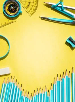 Creative flat lay with blue school supplies on yellow background Stock Photos