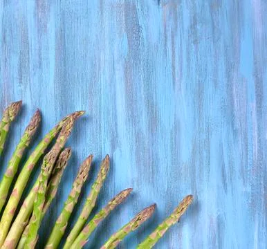 Creative flat lay with bunch of fresh green Asparagus on blue wooden backgrou Foto stock