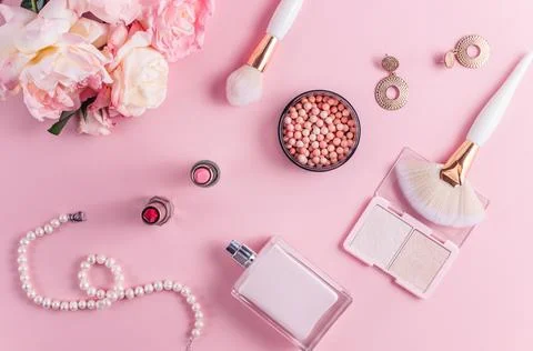 Creative flat lay composition with cosmetics and flowers on pink background.. Stock Photos