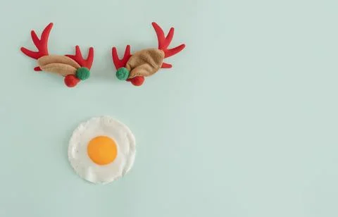 Creative flat lay concept of a reindeer with a poached egg instead of a nos.. Stock Photos