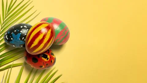 Creative flat lay of four hand-painted Easter eggs and green leaves on a vi.. Stock Photos