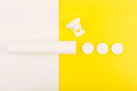 Creative flat lay with opened tube with effervescent vitamins on white and Stock Photos
