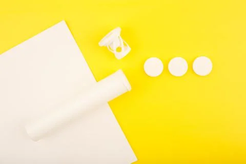 Creative flat lay with opened tube with effervescent vitamins on white and Stock Photos