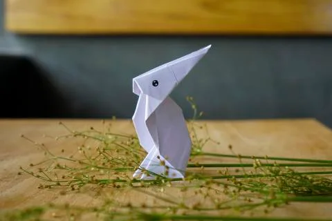 Creative flat lay out. White rabbit paper origami on wooden background with c Stock Photos