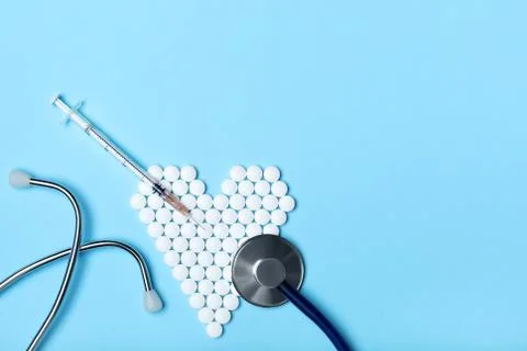 Creative flat lay overhead composition with stethoscope, syringe and heart ma Stock-Fotos