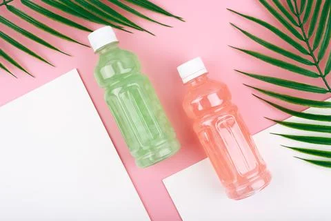 Creative flat lay with two bottles with pink and green detox drinks on pink and Stock Photos
