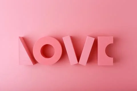 Creative flat lay with word love made of pink geometric figures against light Stock Photos
