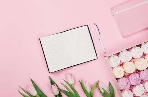 Creative flat lay of workspace desk, notepad for wishlist on pink background Stock Photos