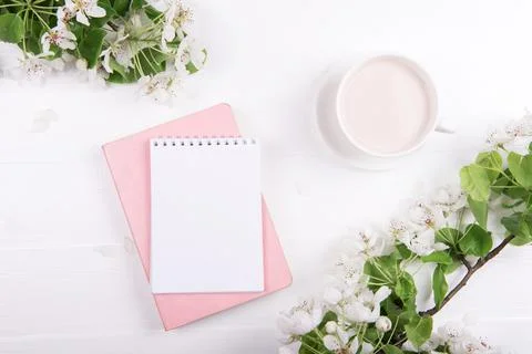 Creative flat lay of workspace desk, notepad and spring blossom Stock Photos