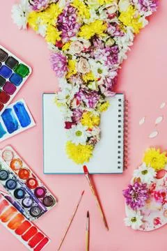 Creative flatlay of notebook with flowers  and watercolors and brushes on pin Stock Photos