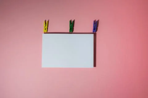 Creative flatlay with a postcard and multi-colored clothespins Stock Photos