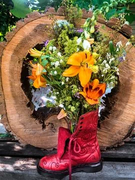 Creative floral arrangement placed inside red boot Stock Photos
