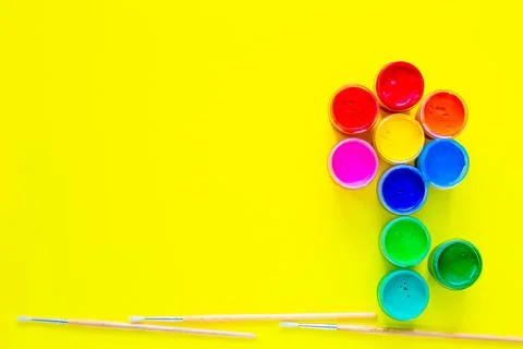 A creative flower made up of cans of paint and brushes for drawing under it on a Stock Photos