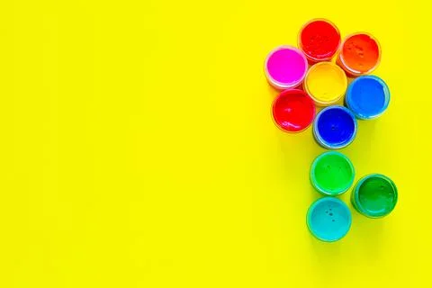A creative flower made up of jars of paint on a yellow background Stock Photos