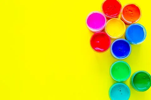 A creative flower made up of jars of paint on a yellow background Stock Photos