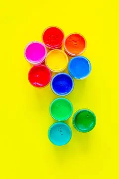 A creative flower made up of jars of paint on a yellow background Stock Photos