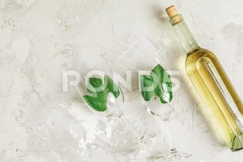 Creative food art background. Bottle of wine and two wineglasses with green g Stock Photos