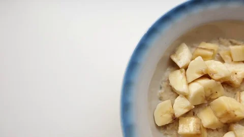 Creative food background. Healthy breakfast, oatmeal porridge with milk and Stock Footage