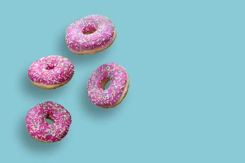 Creative food concept: levitating dounuts isolated on blue background. Stock Photos