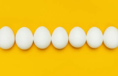 Creative food minimalistic background, Easter. White chicken eggs on yellow Stock Photos