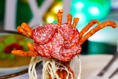 Creative food presentation featuring curled snacks and sliced sausage Stock Photos