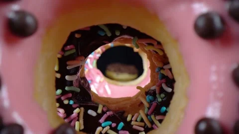 Creative footage with probe lens travelling through doughnut centre Stock Footage