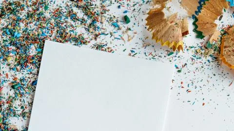 Creative frame made of color pencil shavings a on a white paper. Stock Photos