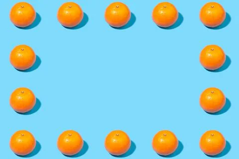 Creative frame of tangerines on a blue background Stock Photos