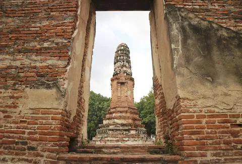 Creative framing shot of ancient Prang chedi viewed through the brick doorway Stock Photos